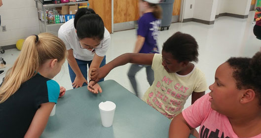 Ph.D. student, Yuexun Tian, showing a vinegaroon to students at Fort White Elementary.
